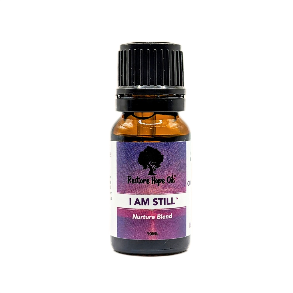 A 10ml traditional dropper bottle of 'I Am Still' Undiluted essential oil blend by Restore Hope Oils, with a purple label.