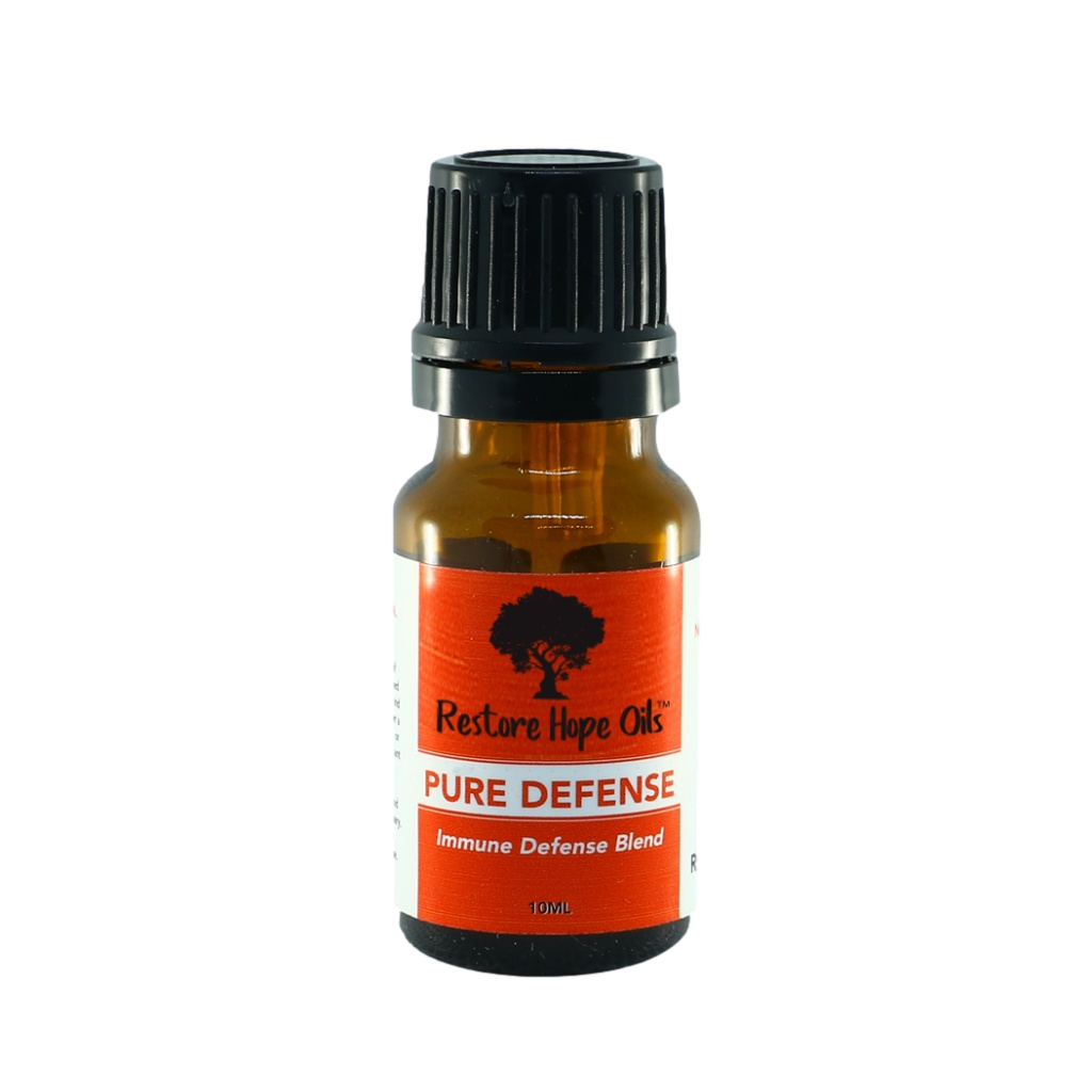 A small amber glass bottle with a black cap labeled 'Pure Defense Immune Defense Blend' by Restore Hope Oils.